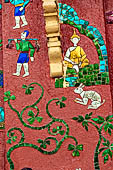 Wat Xieng Thong temple in Luang Prabang, Laos.  La Chapelle Rouge , the Red Chapel. The exterior walls are decorated with colourful mosaics on a pink background with scenes of people daily activities. North wall. 